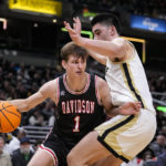 
              Davidson guard Reed Bailey (1) attempts to drives around Purdue center Zach Edey (15) in the second half of an NCAA college basketball game in Indianapolis, Saturday, Dec. 17, 2022. Purdue defeated Davidson 69-61. (AP Photo/Michael Conroy)
            