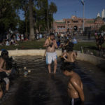 
              Soccer fans wade in water fountain after waiting for hours for a homecoming parade for the players who won the World Cup title, in Buenos Aires, Argentina, Tuesday, Dec. 20, 2022. A parade to celebrate the Argentine World Cup champions was abruptly cut short Tuesday as millions of people poured onto thoroughfares, highways and overpasses in a chaotic attempt to catch a glimpse of the national team. (AP Photo/Rodrigo Abd)
            