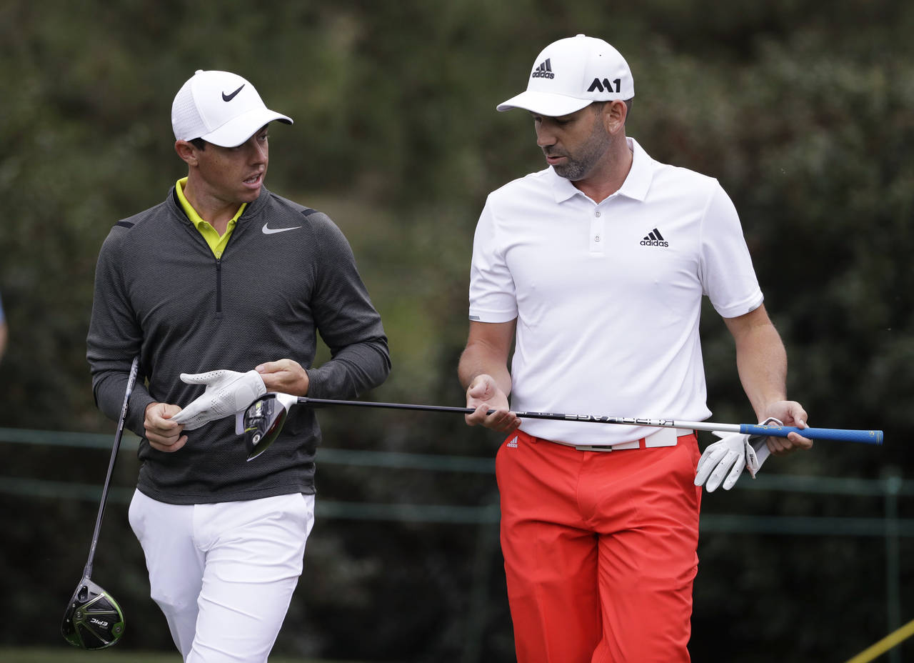 FILE - Rory McIlroy, left, of Northern Ireland, and Sergio Garcia, of Spain, walk up the 15th fairw...