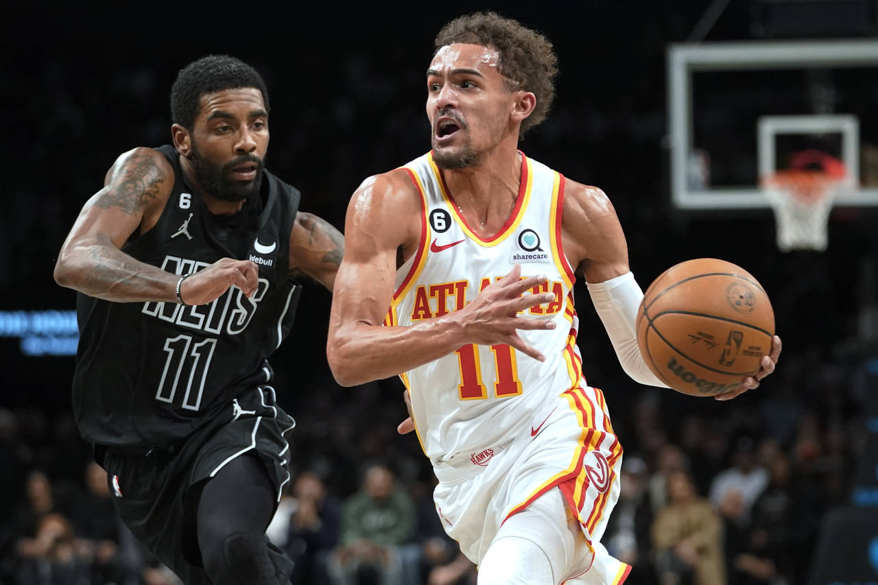 Atlanta Hawks guard Trae Young, right, drives against Brooklyn Nets guard Kyrie Irving during the f...
