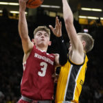 
              Wisconsin guard Connor Essegian (3) drives to the basket ahead of Iowa guard Josh Dix, right, during the first half of an NCAA college basketball game, Sunday, Dec. 11, 2022, in Iowa City, Iowa. (AP Photo/Charlie Neibergall)
            