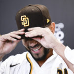 
              San Diego Padres' Xander Bogaerts puts on a Padres cap at a news conference held to announce that his $280 million, 11-year contact with the Padres has been finalized, Friday, Dec. 9, 2022, in San Diego. (AP Photo/Denis Poroy)
            