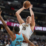 
              Denver Nuggets center Nikola Jokic, back, shoots over Phoenix Suns forward Mikal Bridges in the first half of an NBA basketball game, Sunday, Dec. 25, 2022, in Denver. (AP Photo/David Zalubowski)
            