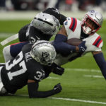 
              New England Patriots tight end Jonnu Smith is taken down by Las Vegas Raiders cornerback Tyler Hall and cornerback Nate Hobbs after a pass reception during the first half of an NFL football game between the New England Patriots and Las Vegas Raiders, Sunday, Dec. 18, 2022, in Las Vegas. (AP Photo/John Locher)
            