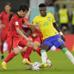 
              Brazil's Vinicius Junior, right, fights for the ball with South Korea's Kim Moon-hwan, left, and Paik Seung-ho during the World Cup round of 16 soccer match between Brazil and South Korea, at the Stadium 974 in Doha, Qatar, Monday, Dec. 5, 2022. (AP Photo/Martin Meissner)
            
