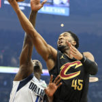 
              Cleveland Cavaliers guard Donovan Mitchell (45) shoots against Dallas Mavericks forward Dorian Finney-Smith, left, during the first half of an NBA basketball game, Saturday, Dec. 17, 2022, in Cleveland. (AP Photo/Nick Cammett)
            