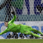 
              Croatia's goalkeeper Dominik Livakovic saves a penalty kick by Japan's Kaoru Mitoma during the World Cup round of 16 soccer match between Japan and Croatia at the Al Janoub Stadium in Al Wakrah, Qatar, Monday, Dec. 5, 2022. (AP Photo/Eugene Hoshiko)
            