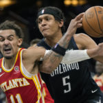 
              Atlanta Hawks' Trae Young, left, fouls Orlando Magic's Paolo Banchero (5) as he goes in for a shot during the second half of an NBA basketball game, Wednesday, Dec. 14, 2022, in Orlando, Fla. (AP Photo/John Raoux)
            