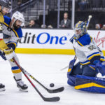 
              Vegas Golden Knights center Michael Amadio (22), defended by St. Louis Blues' Nick Leddy (4), tries to shoot on goaltender Jordan Binnington (50) during the second period of an NHL hockey game Friday, Dec. 23, 2022, in Las Vegas. (AP Photo/L.E. Baskow)
            