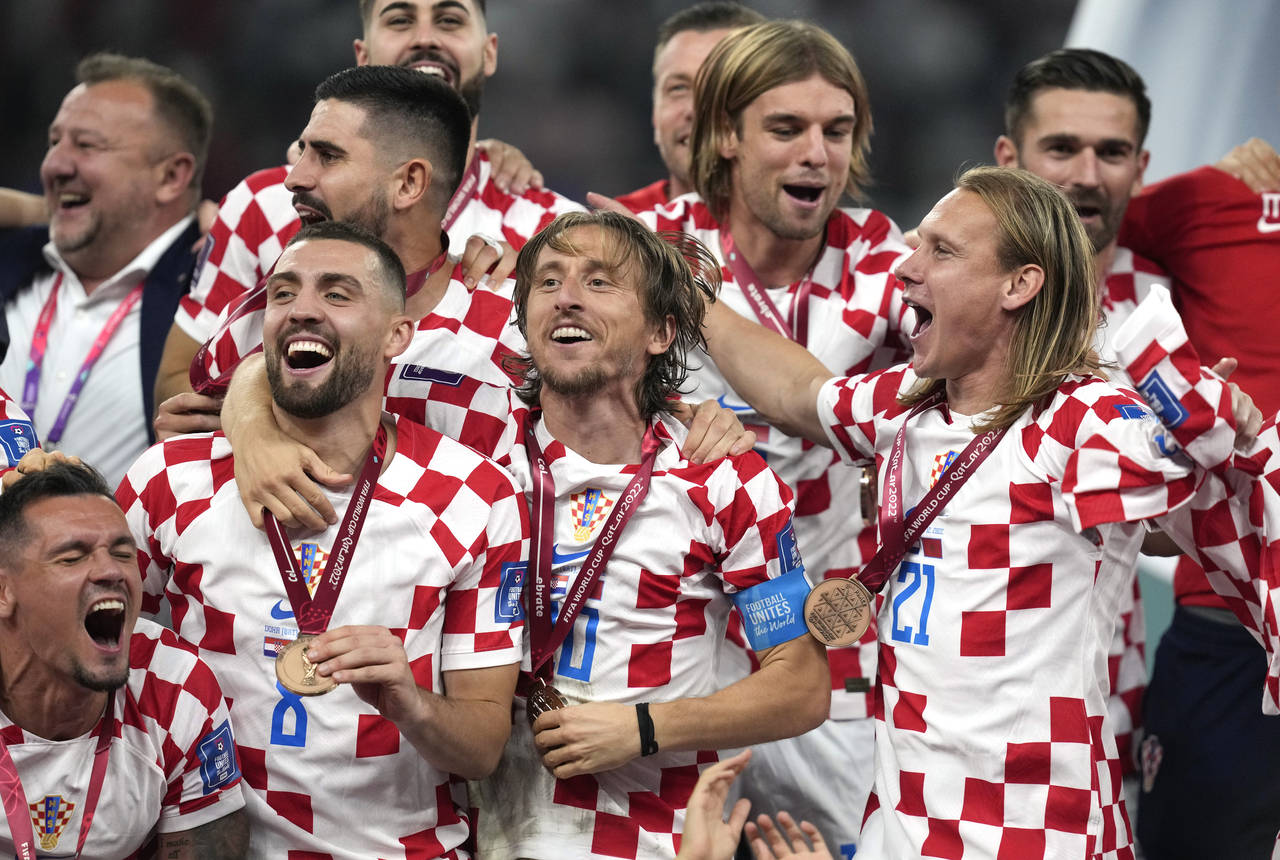 Croat players celebrate on the potdium after winning the World Cup third-place playoff soccer match...