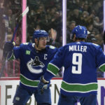 
              Vancouver Canucks' Bo Horvat, left, and J.T. Miller celebrate Horvat's goal against the Montreal Canadiens during the third period of an NHL hockey game in Vancouver, British Columbia, Monday, Dec. 5, 2022. (Darryl Dyck/The Canadian Press via AP)
            