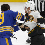 
              Buffalo Sabres center Peyton Krebs (19) and Boston Bruins defenseman Connor Clifton (75) fight during the second period of an NHL hockey game, Saturday, Dec. 31, 2022, in Boston. (AP Photo/Mary Schwalm)
            