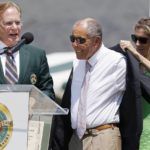 
              FILE - Monica Seles, right, helps Nick Bollettieri with a blazer as Hall of Fame chairman of the board Christopher Clouser, left, looks on during Bollettieri's induction into the International Tennis Hall of Fame in Newport, R.I., Saturday, July 12, 2014. Nick Bollettieri, the Hall of Fame tennis coach who worked with some of the sport’s biggest stars and founded an academy that revolutionized the development of young athletes, has died. He was 91. Bollettieri passed away Sunday night, Dec. 4, 2022, at home in Florida after a series of health issues, his manager, Steve Shulla, said in a telephone interview with The Associated Press on Monday. (AP Photo/Michael Dwyer, File)
            