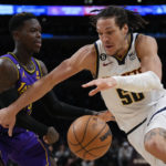 
              Denver Nuggets forward Aaron Gordon (50) controls the ball against Los Angeles Lakers guard Dennis Schroder (17) during the second half of an NBA basketball game in Los Angeles, Friday, Dec. 16, 2022. (AP Photo/Ashley Landis)
            