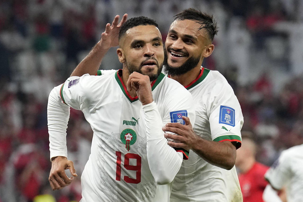 Morocco's Youssef En-Nesyri , left, celebrates beside Morocco's Sofiane Boufal, right, after he sco...