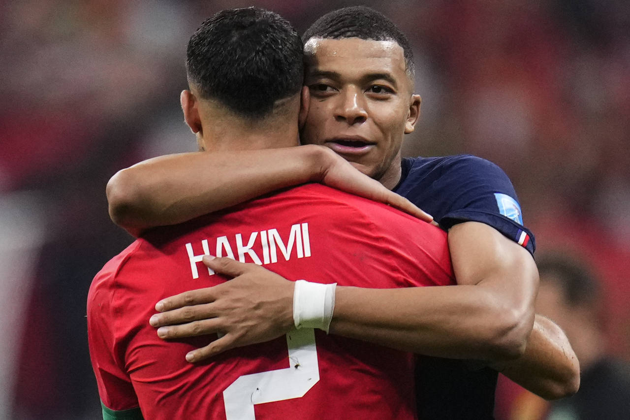 France's Kylian Mbappe hugs Morocco's Achraf Hakimi at the end of the World Cup semifinal soccer ma...