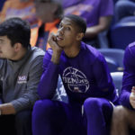 
              Hansel Enmanuel, center, a freshman guard from the Dominican Republic for Northwestern State, on the bench during an NCAA college basketball game against Rice Saturday, Dec. 17, 2022, in Houston. Enmanuel lost his left arm in a childhood accident and has attained the talent and skill to play at the college level. (AP Photo/Michael Wyke)
            