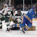 
              St. Louis Blues' Brayden Schenn, right, recoils after being hit by a high stick from Minnesota Wild's Matt Dumba (24) as Wild goaltender Marc-Andre Fleury (29) watches during the second period of an NHL hockey game Saturday, Dec. 31, 2022, in St. Louis. (AP Photo/Jeff Roberson)
            
