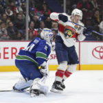 
              Florida Panthers' Matthew Tkachuk, right, deflects the puck wide of the net behind Vancouver Canucks goalie Spencer Martin (30) during the second period of an NHL hockey game Thursday, Dec. 1, 2022, in Vancouver, British Columbia. (Darryl Dyck/The Canadian Press via AP)
            