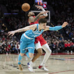 
              Portland Trail Blazers guard Anfernee Simons, top, and Charlotte Hornets guard LaMelo Ball collide during the first half of an NBA basketball game in Portland, Ore., Monday, Dec. 26, 2022. (AP Photo/Craig Mitchelldyer)
            