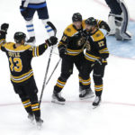 
              Boston Bruins left wing Nick Foligno (17) is congratulated for his goal against the Winnipeg Jets by Trent Frederic (11) and Charlie Coyle (13) during the third period of an NHL hockey game Thursday, Dec. 22, 2022, in Boston. (AP Photo/Mary Schwalm)
            