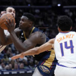 
              New Orleans Pelicans forward Zion Williamson drives to the basket between Phoenix Suns forward Dario Saric (20) and guard Landry Shamet (14) in the second half of an NBA basketball game in New Orleans, Sunday, Dec. 11, 2022. The Pelicans won 129-124. (AP Photo/Gerald Herbert)
            