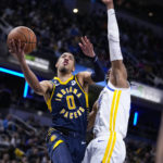 
              Indiana Pacers guard Tyrese Haliburton (0) shoots over Golden State Warriors forward Jonathan Kuminga (00) during the second half of an NBA basketball game in Indianapolis, Wednesday, Dec. 14, 2022. The Pacers defeated the Warriors 125-119. (AP Photo/Michael Conroy)
            