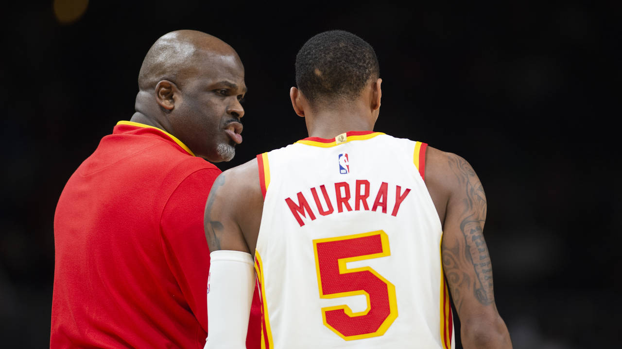Atlanta Hawks head coach Nate McMillan, left, speaks to guard Dejounte Murray (5) during the second...
