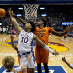 
              Kansas Jayhawks forward Jalen Wilson (10) and Oklahoma State forward Kalib Boone (22) battle for a rebound during the first half of an NCAA college basketball game Saturday, Dec. 31, 2022, in Lawrence, Kan. (AP Photo/Charlie Riedel)
            
