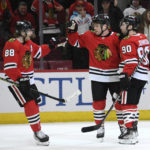 
              Chicago Blackhawks' Max Domi (13) celebrates with Patrick Kane (88) and Tyler Johnson (90) after scoring against the Columbus Blue Jackets during the first period of an NHL hockey game Friday, Dec. 23, 2022, in Chicago. (AP Photo/Paul Beaty)
            