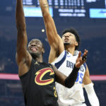
              Dallas Mavericks forward Christian Wood, right, blocks a shot by Cleveland Cavaliers guard Caris LeVert, left, during the first half of an NBA basketball game, Saturday, Dec. 17, 2022, in Cleveland. (AP Photo/Nick Cammett)
            