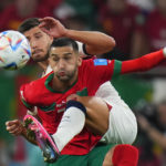 
              Morocco's Hakim Ziyech, foreground, fights for the ball with Portugal's Ruben Dias during the World Cup quarterfinal soccer match between Morocco and Portugal, at Al Thumama Stadium in Doha, Qatar, Saturday, Dec. 10, 2022. (AP Photo/Petr David Josek)
            