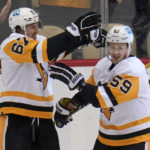
              Pittsburgh Penguins' Rickard Rakell (67) celebrates his goal against the Buffalo Sabres with Jake Guentzel (59) during the first period of an NHL hockey game in Pittsburgh, Saturday, Dec. 10, 2022. (AP Photo/Gene J. Puskar)
            