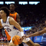 
              Kansas Jayhawks forward Jalen Wilson (10) drives under pressure from Oklahoma State guard Avery Anderson III, right, during the first half of an NCAA college basketball game Saturday, Dec. 31, 2022, in Lawrence, Kan. (AP Photo/Charlie Riedel)
            