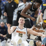 
              Denver Nuggets center Nikola Jokic, lower left, looks to referees for a call after he and Memphis Grizzlies guard Ja Morant, lying on court, as Grizzlies forward Jaren Jackson Jr., top, and Nuggets guard Kentavious Caldwell-Pope look on during the second half of an NBA basketball game Tuesday, Dec. 20, 2022, in Denver. (AP Photo/David Zalubowski)
            