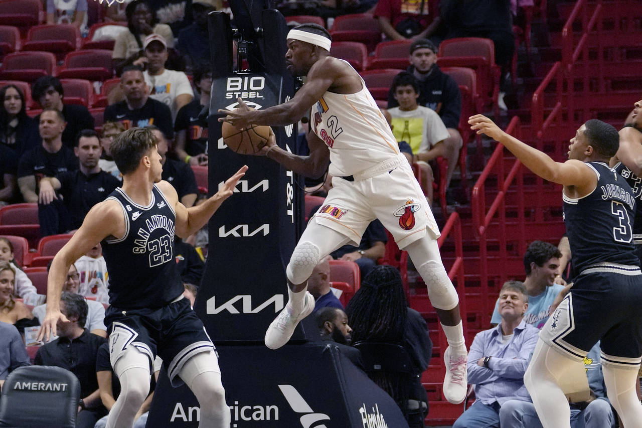 Miami Heat forward Jimmy Butler (22) looks to pass the ball as San Antonio Spurs forward Zach Colli...