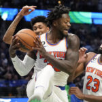 
              New York Knicks forward Julius Randle (30) grabs a rebound in front of Mitchell Robinson (23) and Dallas Mavericks forward Christian Wood during the first half of an NBA basketball game in Dallas, Tuesday, Dec. 27, 2022. (AP Photo/LM Otero)
            