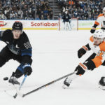 
              Toronto Maple Leafs right wing Mitchell Marner (16) and Philadelphia Flyers defenseman Tony DeAngelo (77) battle for the puck during the second period of an NHL hockey game, Thursday, Dec. 22, 2022 in Toronto. (Chris Young/The Canadian Press via AP)
            