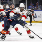 
              New York Islanders center Jean-Gabriel Pageau, left, checks Florida Panthers forward Givani Smith during the first period of an NHL hockey game Friday, Dec. 23, 2022, in Elmont, N.Y. (AP Photo/John Munson)
            