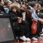 
              Drake sits with his son Adonis Graham as they watch the Toronto Raptors take on the Los Angeles Lakers during the first half of an NBA basketball game Wednesday, Dec. 7, 2022, in Toronto. (Chris Young/The Canadian Press via AP)
            