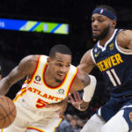 
              Atlanta Hawks guard Dejounte Murray drives to the basket past Denver Nuggets forward Bruce Brown during the first half of an NBA basketball game Friday, Dec. 2, 2022, in Atlanta. (AP Photo/Hakim Wright Sr.)
            