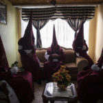 
              Members of the Nazarene brotherhood sit in a living room as they wait to take part in a Good Friday procession in Zipaquira, Colombia, on April 15, 2022. (AP Photo/Ivan Valencia)
            