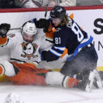 
              Anaheim Ducks' Sam Carrick (39) collides with Winnipeg Jets' Kyle Connor (81) during the third period of an NHL Hockey game in Winnipeg, Manitoba on Sunday, Dec. 4, 2022. (Fred Greenslade/The Canadian Press via AP)
            
