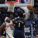 
              Phoenix Suns forward Torrey Craig (0) tries to stop New Orleans Pelicans forward Zion Williamson (1) as he drives to the basket in the first half of an NBA basketball game in New Orleans, Sunday, Dec. 11, 2022. (AP Photo/Gerald Herbert)
            