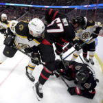 
              Boston Bruins left wing Tomas Nosek tries to find the puck under the chest of Ottawa Senators defenseman Travis Hamonic past center Shane Pinto, as they battle in the corner during the first period of an NHL hockey game in Ottawa, Ontario, on Tuesday, Dec. 27, 2022. (Justin Tang/The Canadian Press via AP)
            