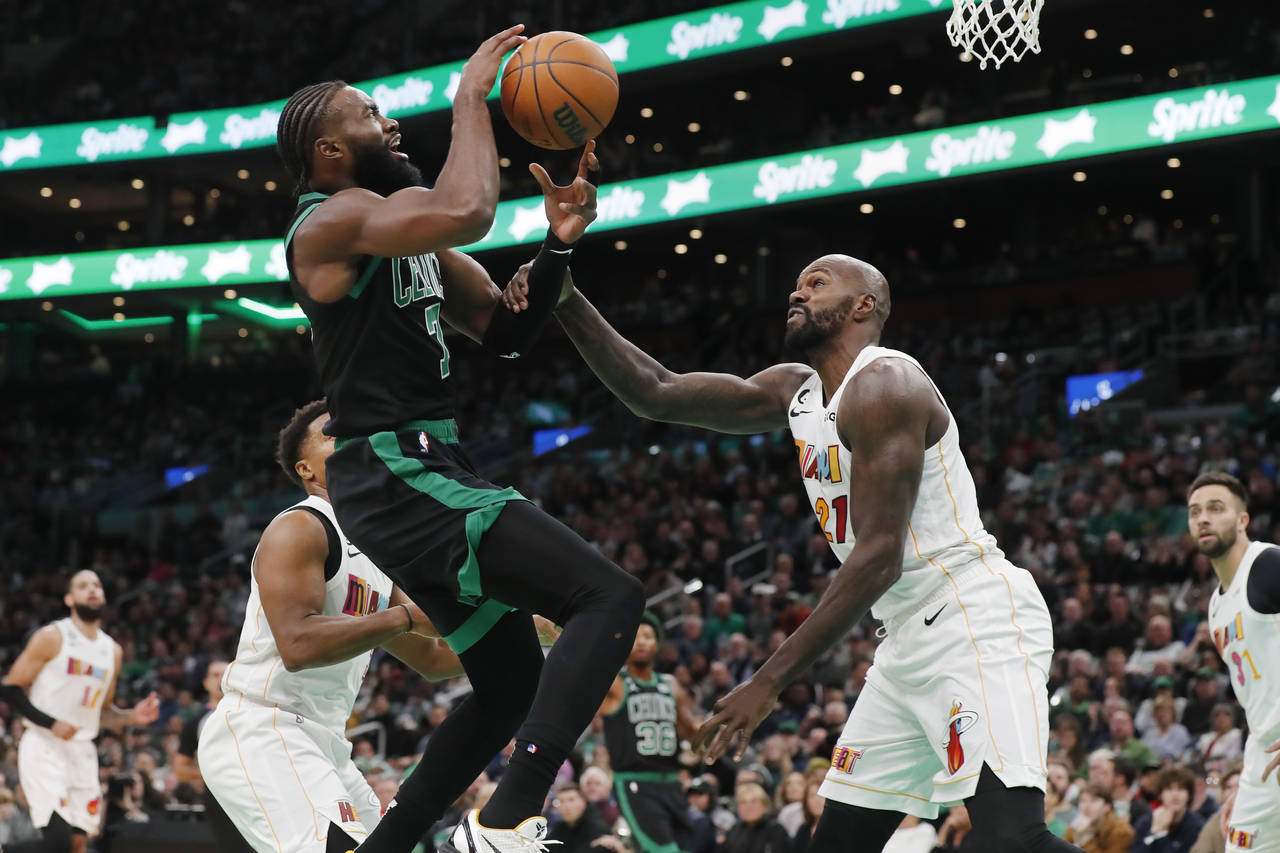 Boston Celtics' Jaylen Brown (7) shoots against Miami Heat's Dewayne Dedmon (21) during the first h...
