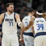 
              Dallas Mavericks guard Luka Doncic (77) high-fives guard Kemba Walker (34) during the first half of an NBA basketball game against the Minnesota Timberwolves, Wednesday, Dec. 21, 2022, in Minneapolis. (AP Photo/Abbie Parr)
            