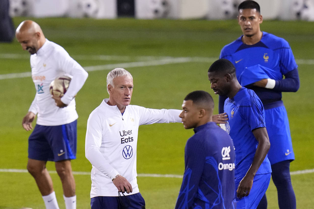 France's head coach Didier Deschamps talks to his players during the training session at the Jassim...
