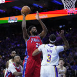 
              Philadelphia 76ers' Joel Embiid, center, goes up for a shot against Los Angeles Lakers' Anthony Davis during the first half of an NBA basketball game, Friday, Dec. 9, 2022, in Philadelphia. (AP Photo/Matt Slocum)
            