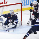 
              Columbus Blue Jackets' Gustav Nyquist (14) scores on Winnipeg Jets goaltender David Rittich (33) as Neal Pionk (4) defends during the second period of an NHL hockey game Friday, Dec. 2, 2022, in Winnipeg, Manitoba. (John Woods/The Canadian Press via AP)
            